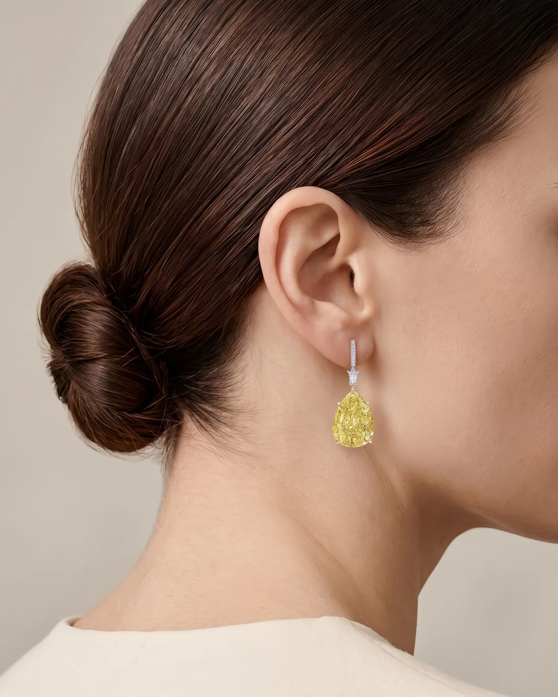 ORTIGAS Yellow Pear Drops earrings, worn on the ear