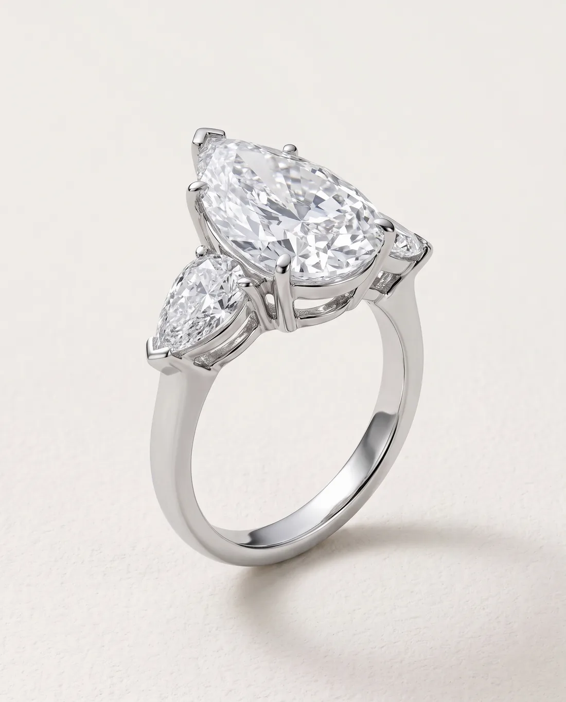 ORTIGAS Pear three-stone ring, three-quarter view